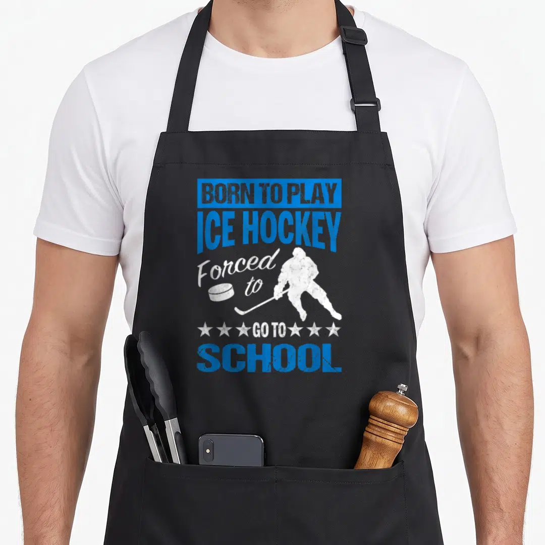 Play forced school apron - Blue and white distressed hockey player silhouette with BORN TO PLAY ICE HOCKEY text — shown on a black cotton canvas apron against a white background