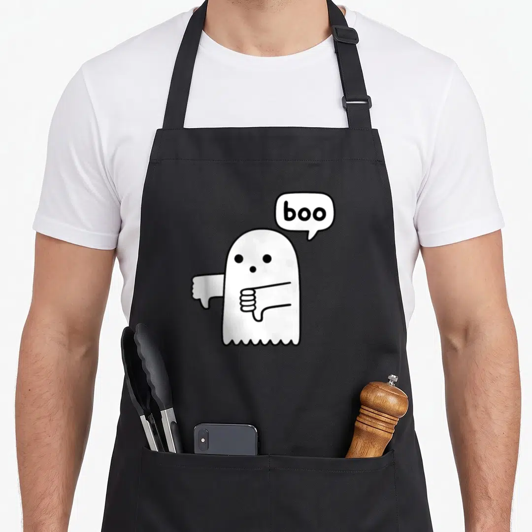 Thumb ghost apron - White cartoon ghost with black outline giving two thumbs down next to a speech bubble reading boo — shown on a black cotton canvas apron against a white background