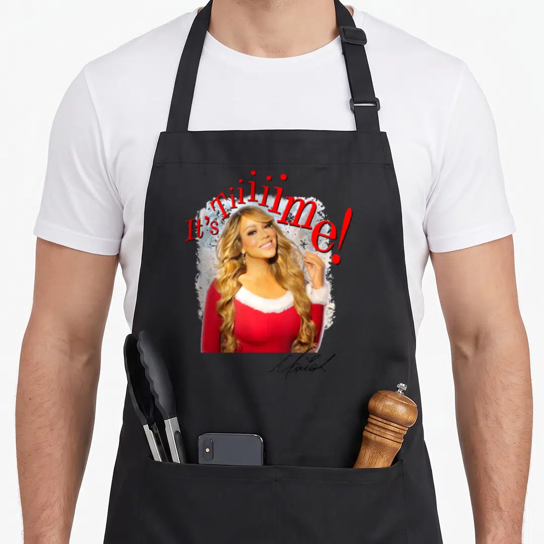 Mariah 30th apron - Photo of Mariah Carey in red dress with white trim under red It's Tiililme text and signature — shown on a black cotton canvas apron against a white background