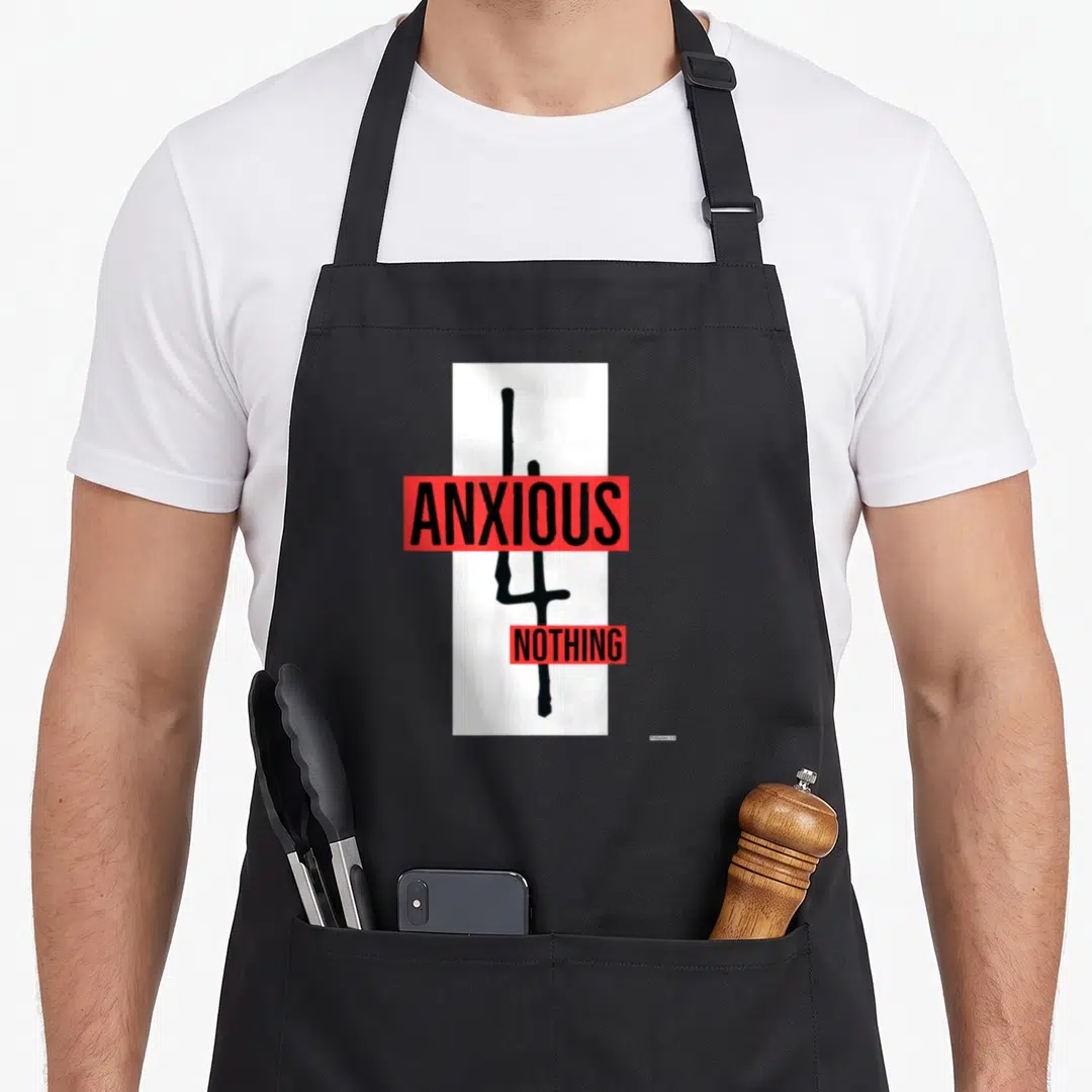 Vintage anxious apron - Black cross on white with red bars reading ANXIOUS NOTHING — shown on a black cotton canvas apron against a white background