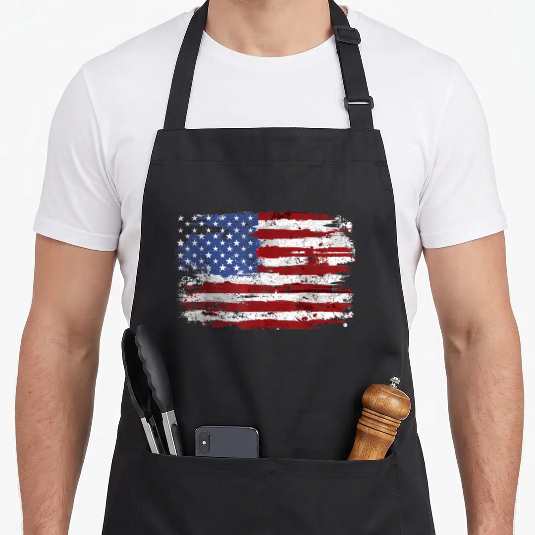Occasion 4th of july apron - Distressed USA flag in red white and blue on black apron — shown on a black cotton canvas apron against a white background