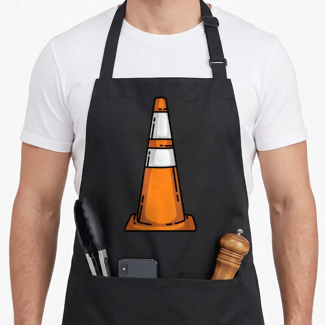 Traffic halloween apron - Cartoon orange and white traffic cone with black outlines — shown on a black cotton canvas apron against a white background