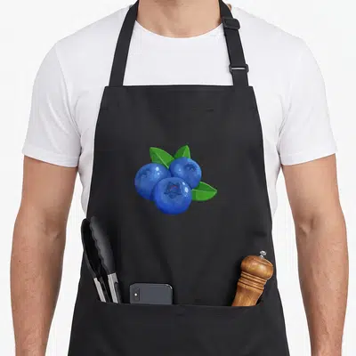 Berry fruit apron - Three blue cartoon blueberries with three green leaves tucked behind them — shown on a black cotton canvas apron against a white background