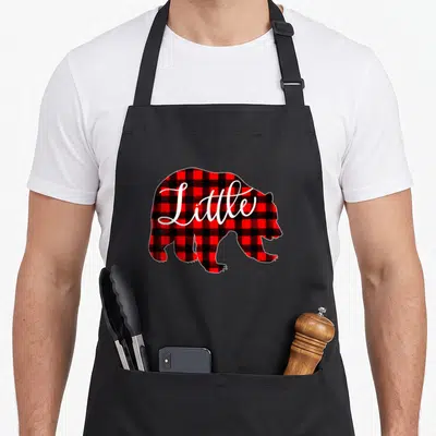 Bear family buffalo plaid christmas apron - Red and black plaid bear silhouette with Little in white script — shown on a black cotton canvas apron against a white background