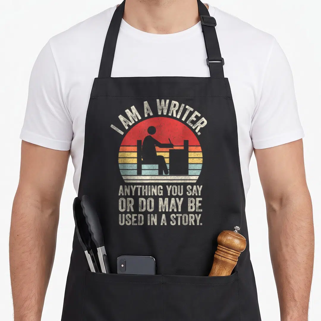 Catch author apron - Retro sun graphic with writer silhouette and text about using real life in stories — shown on a black cotton canvas apron against a white background