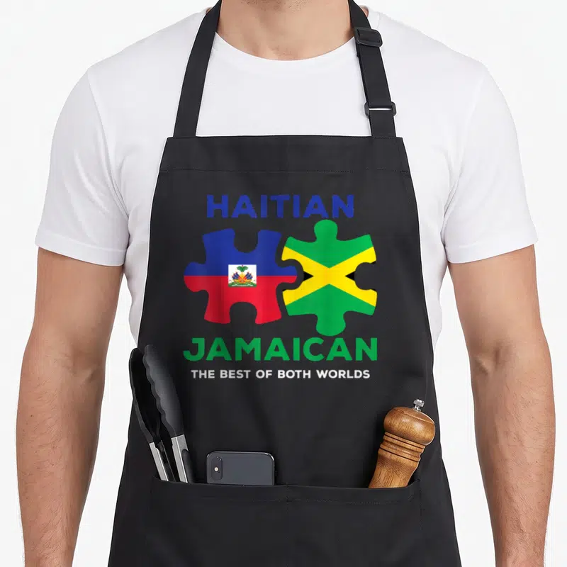 Haiti creole apron - HAITIAN JAMAICAN puzzle pieces with Haitian and Jamaican flags in blue red green yellow white — shown on a black cotton canvas apron against a white background