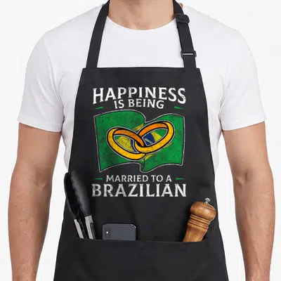 Marriage brazilian food apron - Happiness Is Being Married To A Brazilian text over Brazil flag and two gold rings — shown on a black cotton canvas apron against a white background