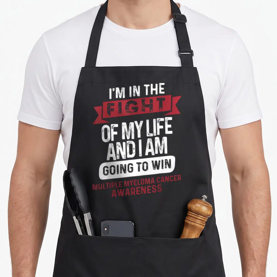 Myeloma cancer ribbon apron - Stacked white and red text with red ribbon banner and white capsule reading I'm — shown on a black cotton canvas apron against a white background