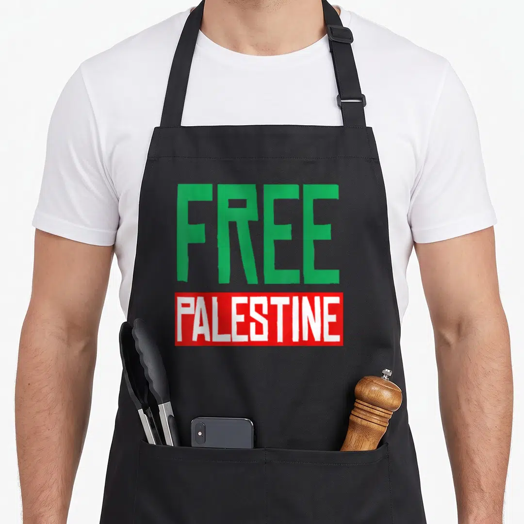 Free palestine apron for men - Green FREE text above red rectangle with white PALESTINE typography design — shown on a black cotton canvas apron against a white background