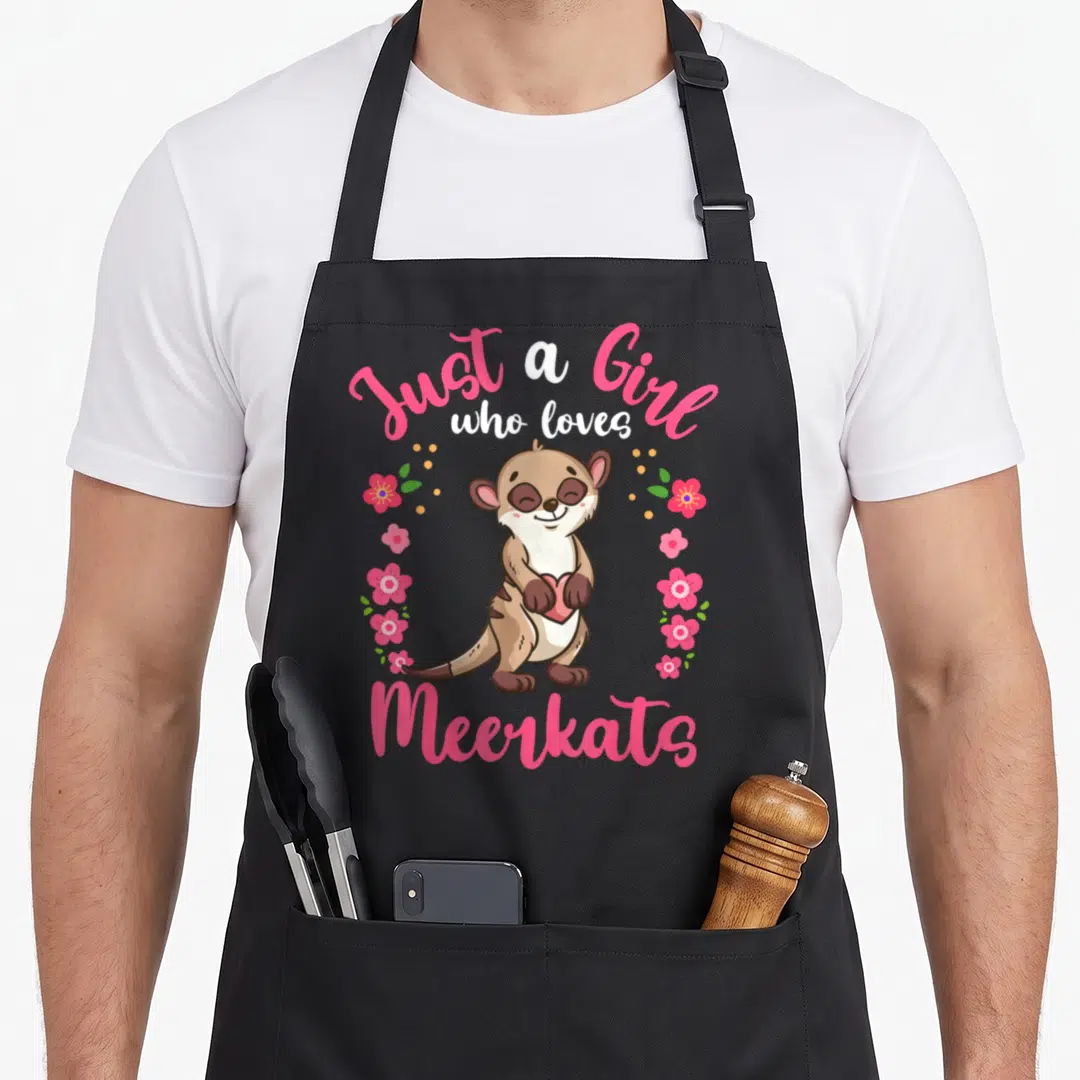 Meerkat apron for kids - Cartoon meerkat holding pink heart with pink flowers and text Just a Girl who loves Meerkats — shown on a black cotton canvas apron against a white background