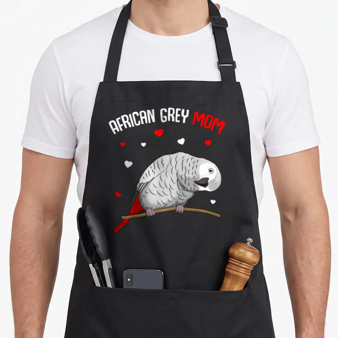 Funny parrot african aprons - African Grey Mom text above a grey parrot on a branch with red and white hearts — shown on a black cotton canvas apron against a white background
