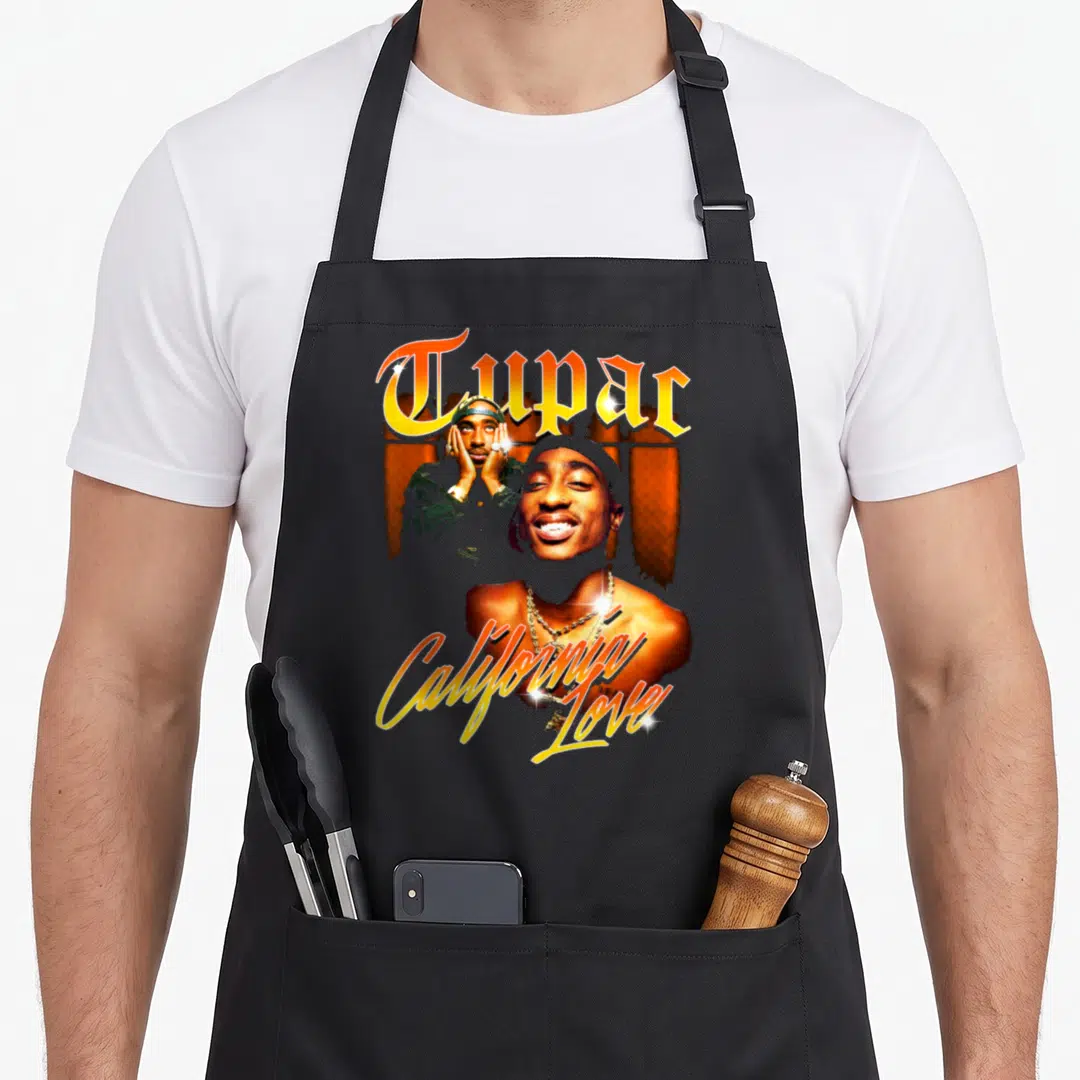California tupac apron - Photo collage of Tupac Shakur with orange and gold California Love text — shown on a black cotton canvas apron against a white background