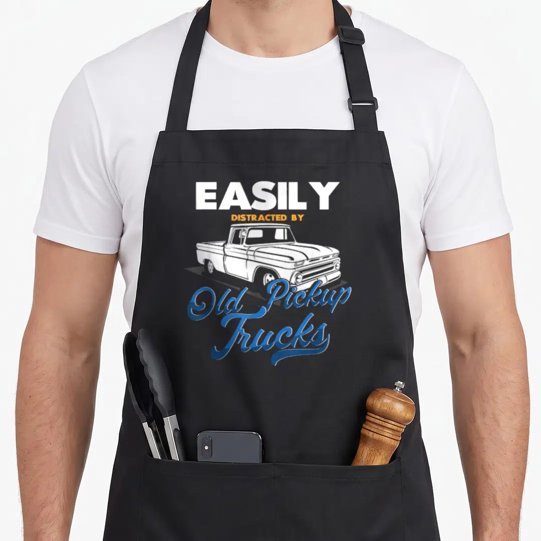 Distracted pickup car truck apron - Retro white pickup truck illustration with EASILY DISTRACTED BY Old Pickup Trucks — shown on a black cotton canvas apron against a white background