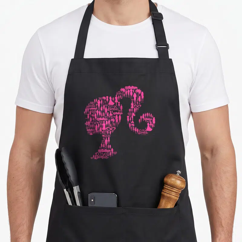 Silhouette lifestyle apron - Pink Barbie silhouette made of small icons including cars, palm trees, and text — shown on a black cotton canvas apron against a white background