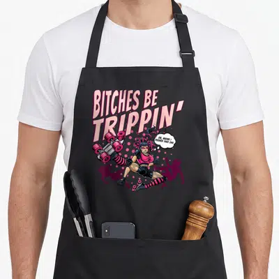Trippin wheel girl apron - Cartoon skater kicking board with pink text Bitches Be Trippin and thought bubble — shown on a black cotton canvas apron against a white background