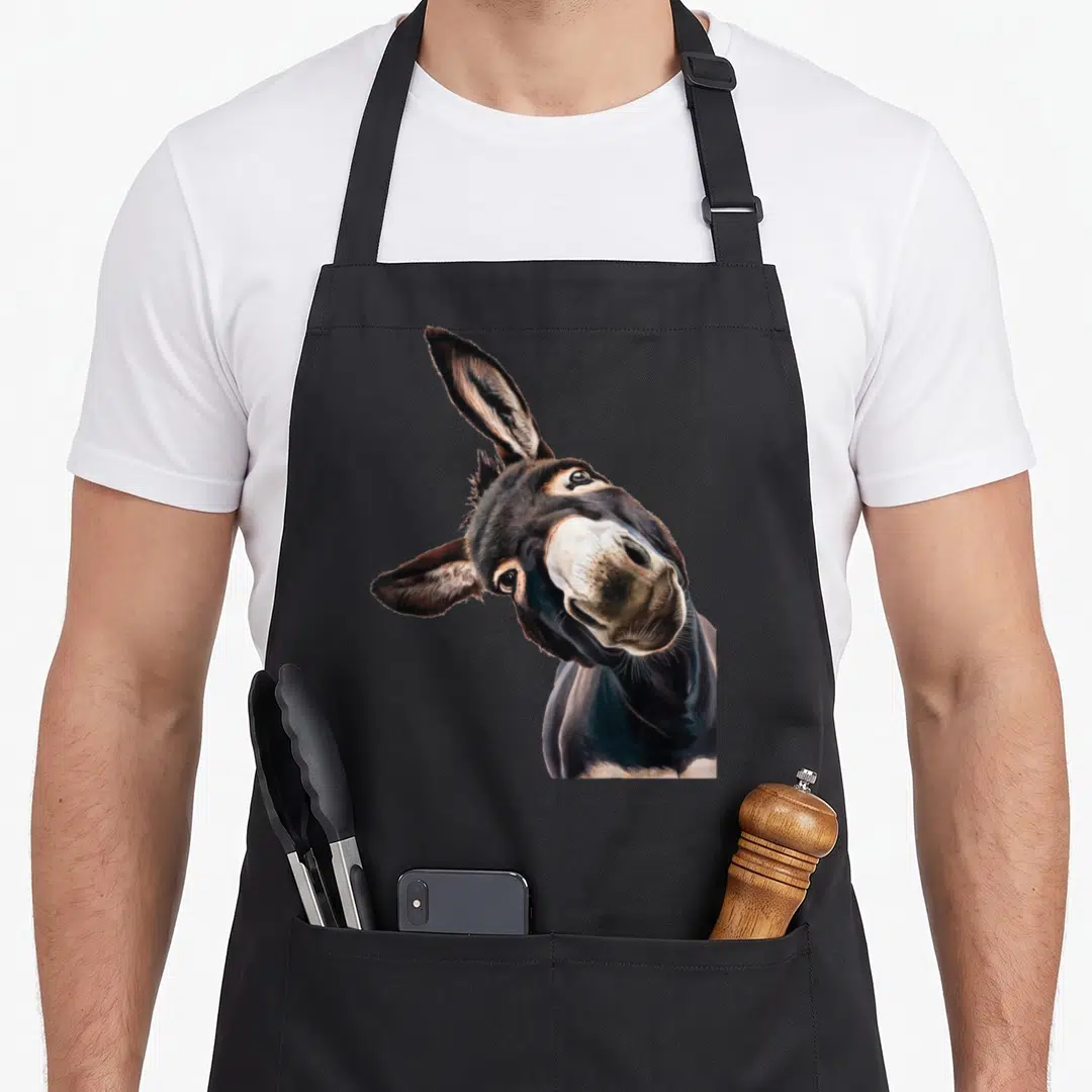 Animal quirky apron - Realistic donkey head tilted sideways in brown grey and white photo art — shown on a black cotton canvas apron against a white background