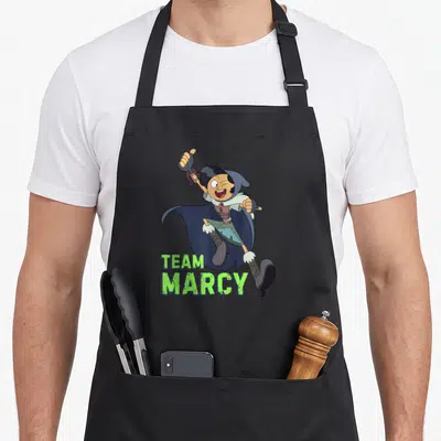 Channel jet girl apron - Cartoon Marcy character with green Team Marcy text below — shown on a black cotton canvas apron against a white background