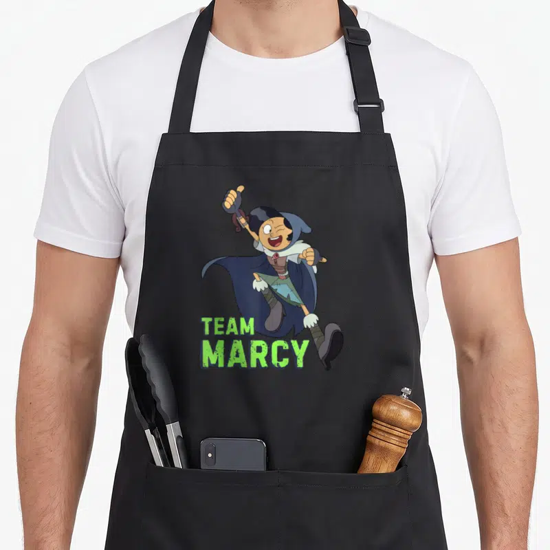 Channel jet girl apron - Cartoon Marcy character with green Team Marcy text below — shown on a black cotton canvas apron against a white background