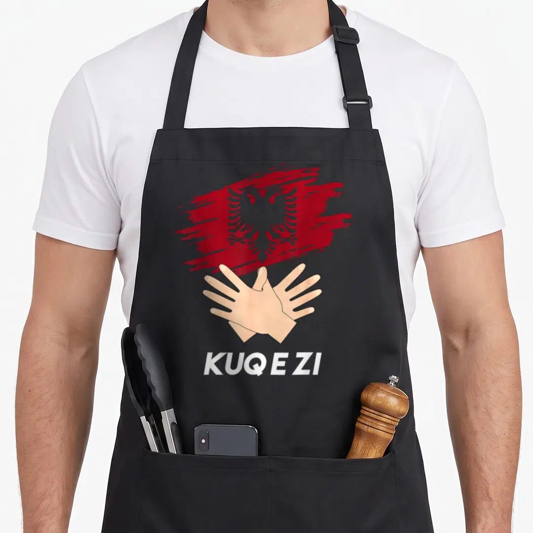 Shqiponja eagles apron - Red brush-stroke flag with crossed hands and white text KUQ E ZI — shown on a black cotton canvas apron against a white background