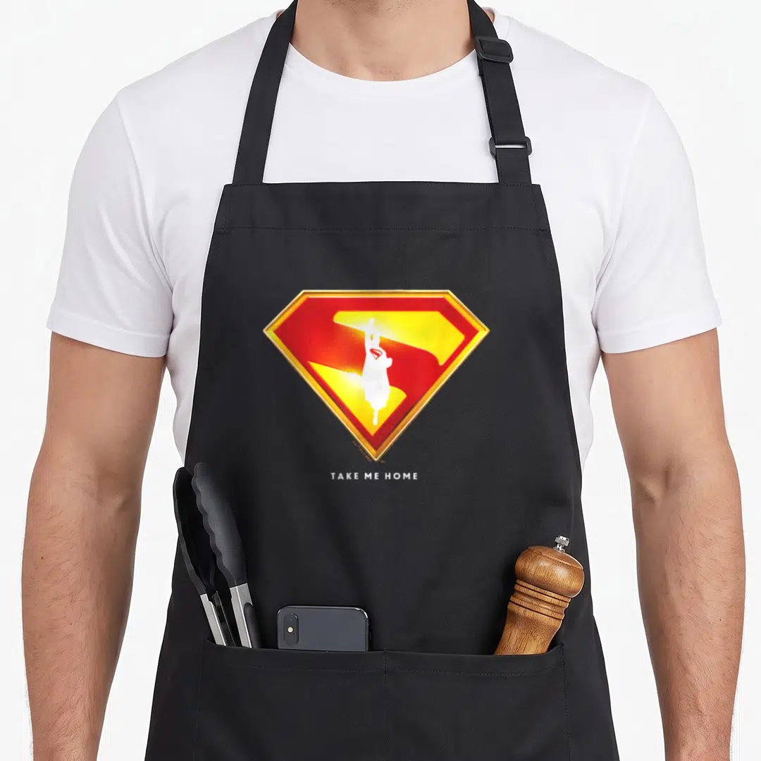 Exclusive novelty apron - Red yellow gold shield with white silhouette and Take Me Home text below — shown on a black cotton canvas apron against a white background