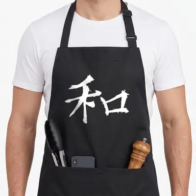 Peace japan apron - White brush-stroke kanji character centered on dark background — shown on a black cotton canvas apron against a white background