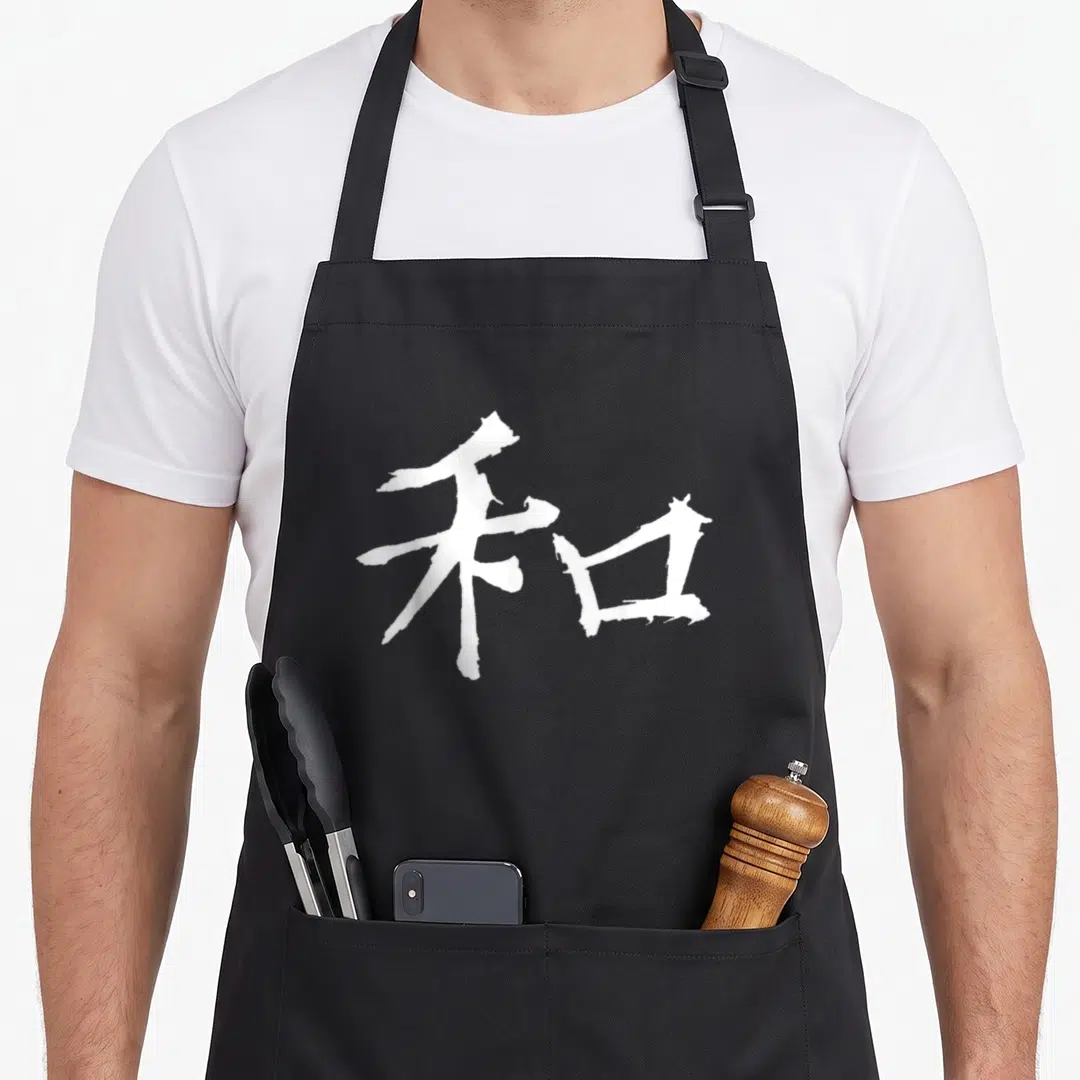 Peace japan apron - White brush-stroke kanji character centered on dark background — shown on a black cotton canvas apron against a white background