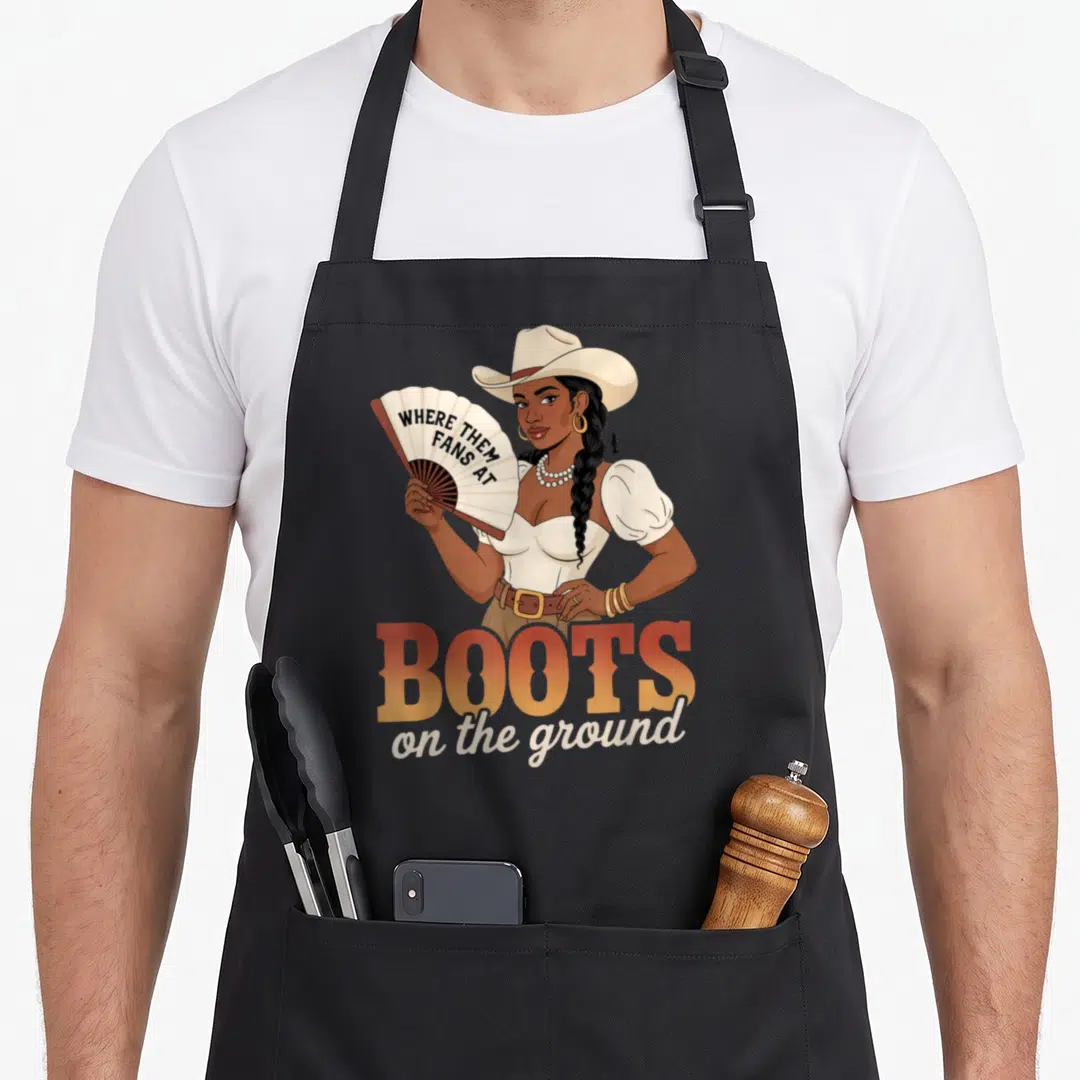Boot line apron - Woman holding fan reading where them fans at above boots on the ground text — shown on a black cotton canvas apron against a white background