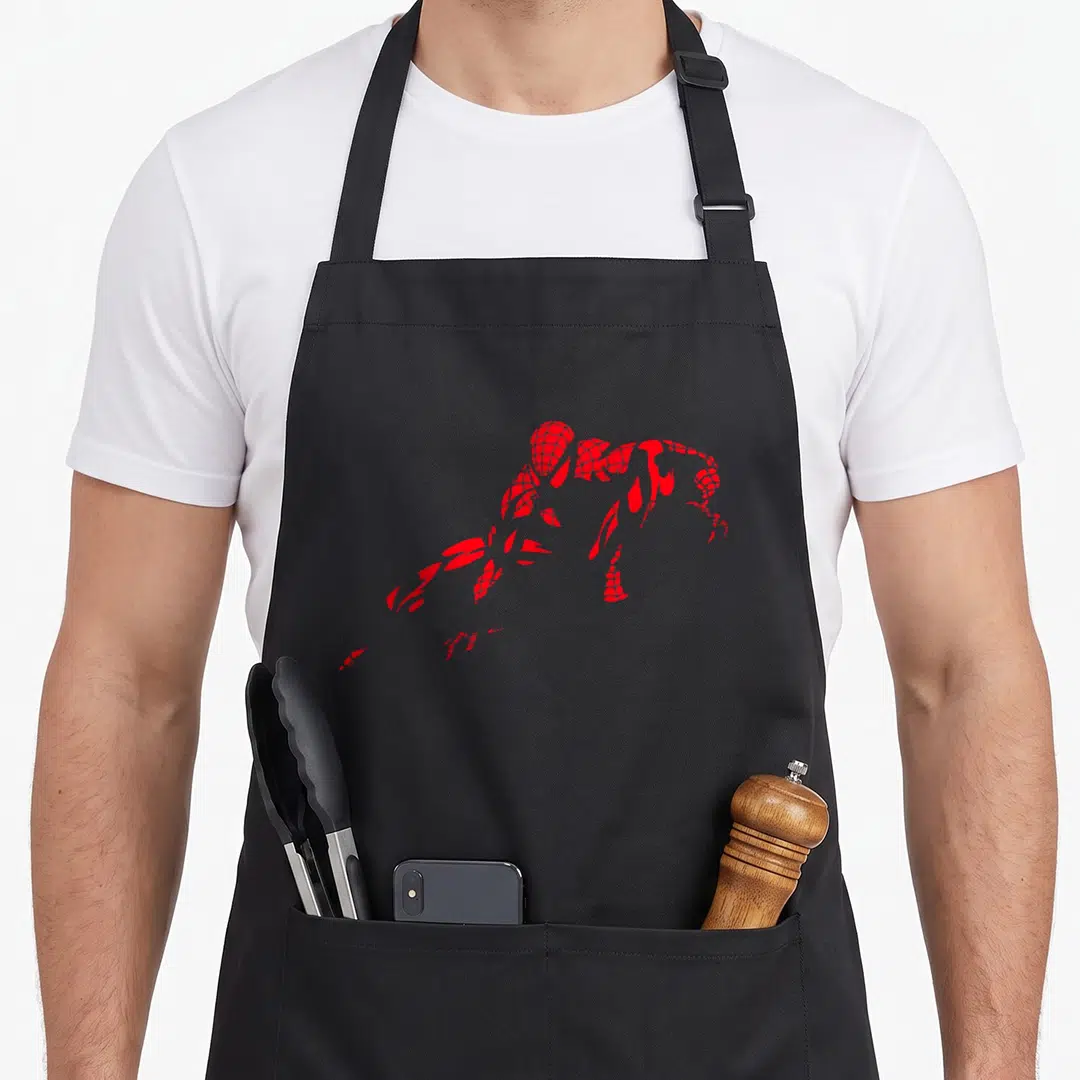Fan paris apron - Red fragmented Spider-Man silhouette crouching pose on grey background — shown on a black cotton canvas apron against a white background