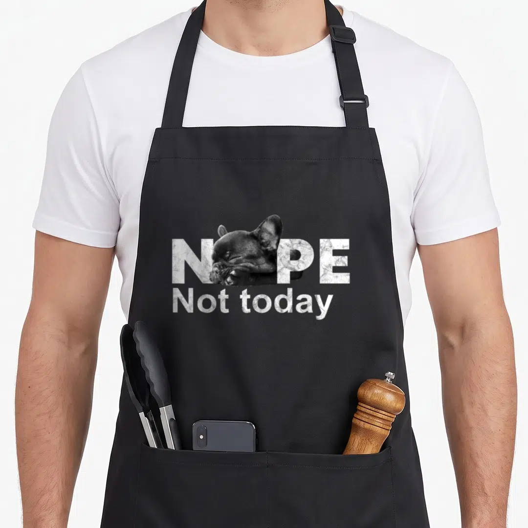 Today french bulldog apron - Sleeping french bulldog head replacing the O in NOPE Not today distressed text — shown on a black cotton canvas apron against a white background