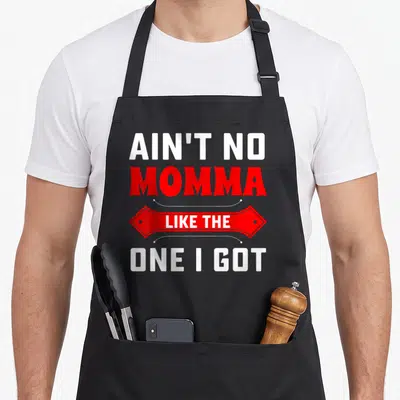 Momma dad mode apron - Stacked white and red text reading Ain't No Momma Like The One I Got with decorative banner — shown on a black cotton canvas apron against a white background
