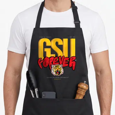 Yard essential apron - Grambling Louisiana EST 1901 GSU FOREVER tiger head typography design on black apron — shown on a black cotton canvas apron against a white background