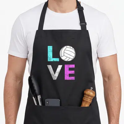 Volleyball birthday apron - LOVE text with volleyball replacing O in cyan white and pink — shown on a black cotton canvas apron against a white background