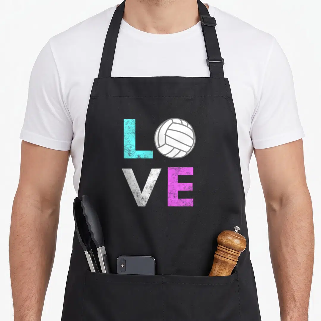 Volleyball birthday apron - LOVE text with volleyball replacing O in cyan white and pink — shown on a black cotton canvas apron against a white background