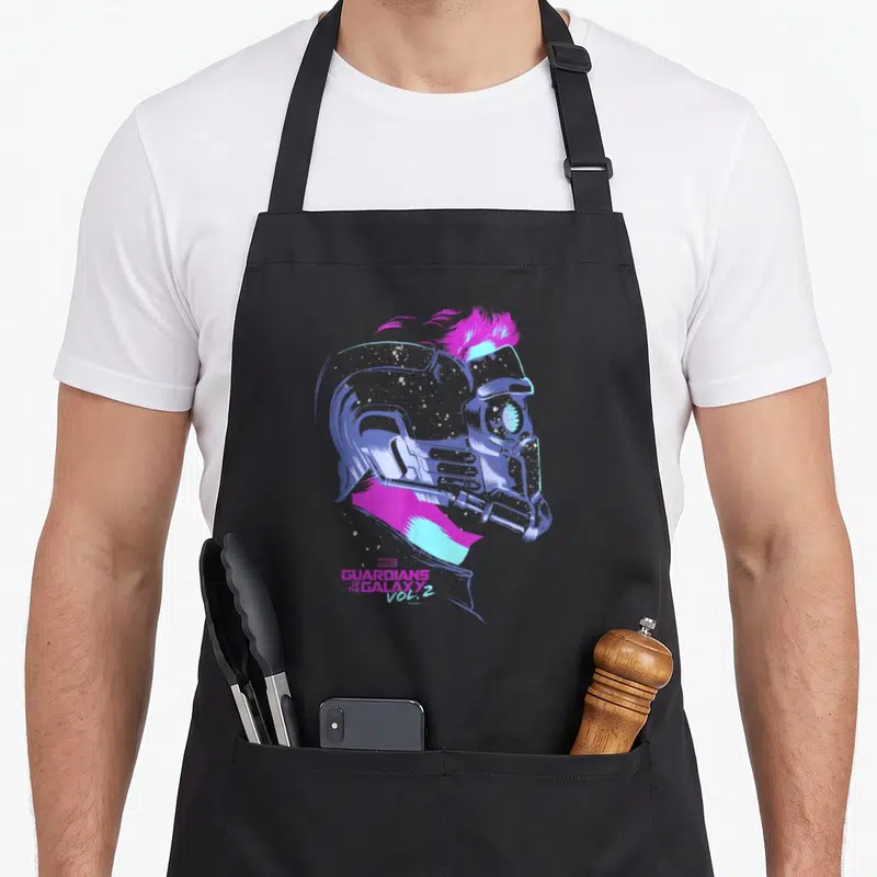 Lord galaxies apron - Star-Lord helmet profile in pink blue purple with Guardians Galaxy Vol 2 text — shown on a black cotton canvas apron against a white background