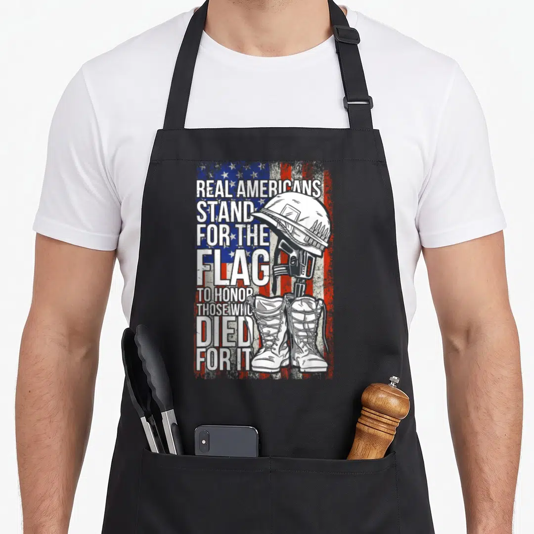 Veteran patriots apron - Distressed flag with helmet rifle boots silhouette and honor text — shown on a black cotton canvas apron against a white background