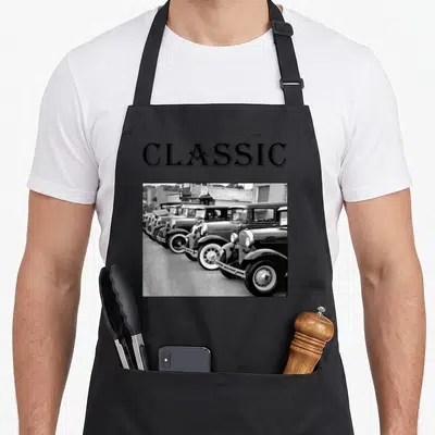 Father antique apron - CLASSIC text above b&w photo of vintage car row — shown on a black cotton canvas apron against a white background