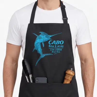 Jcomb striped apron - Blue marlin illustration next to stacked CABO SAN LUCAS LOS CABOS BAJA SUR text — shown on a black cotton canvas apron against a white background
