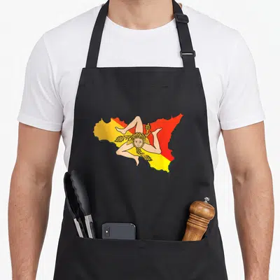 Sicilia travel aprons - Sicily map outline in yellow and red with a stylized figure holding wheat stalks — shown on a black cotton canvas apron against a white background