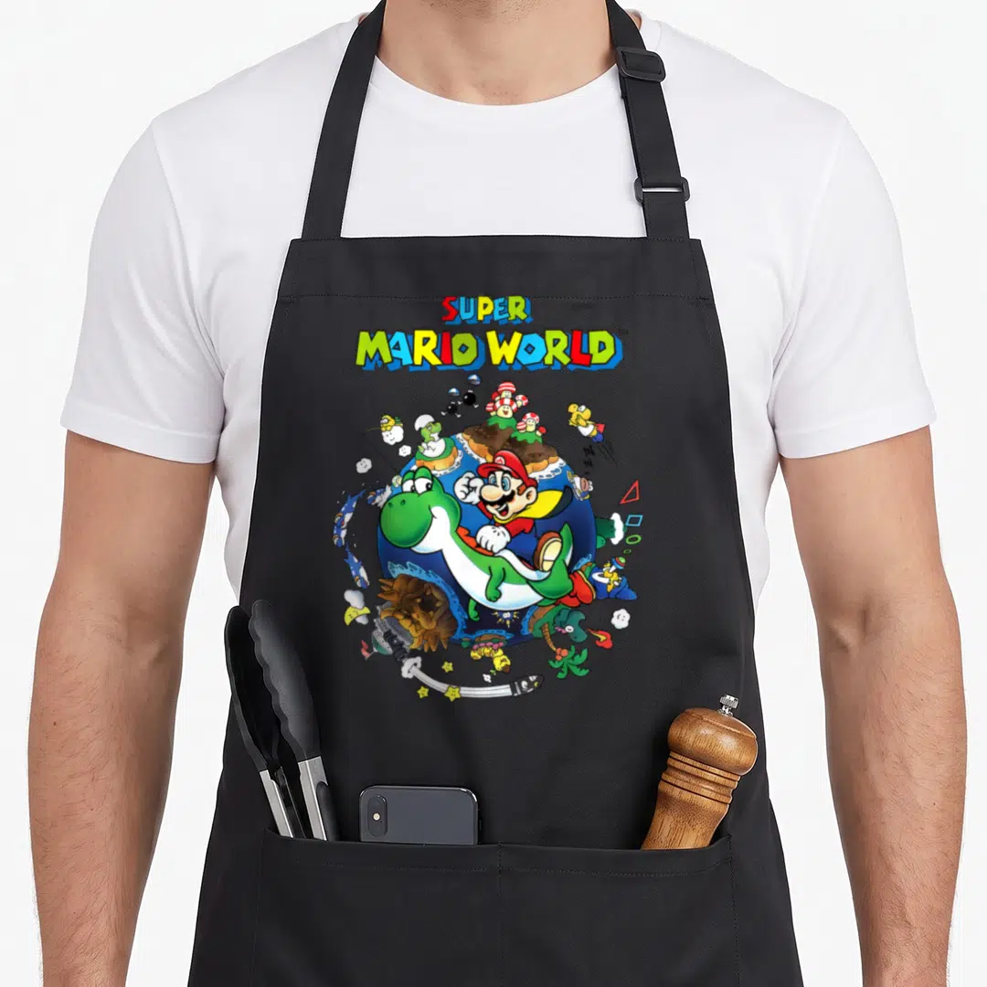 Around novelty apron - Super Mario World text above Mario riding Yoshi around a blue planet with game characters — shown on a black cotton canvas apron against a white background