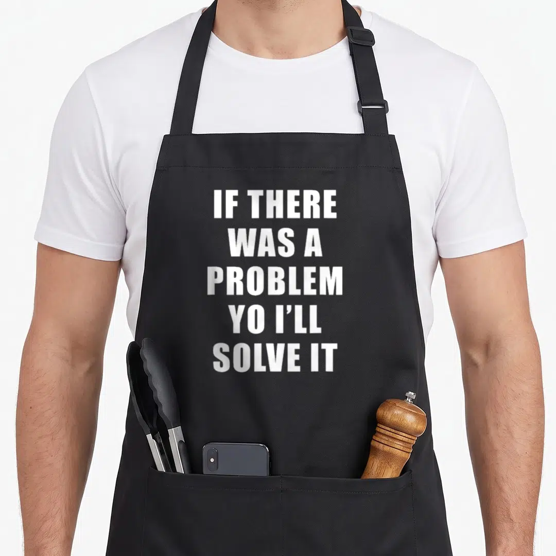 Problem ice apron - White stacked text reading IF THERE WAS A PROBLEM YO I'LL SOLVE IT — shown on a black cotton canvas apron against a white background