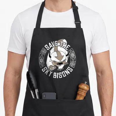 Save sky apron - Cartoon bison in white and tan with arched text and circular border symbols — shown on a black cotton canvas apron against a white background