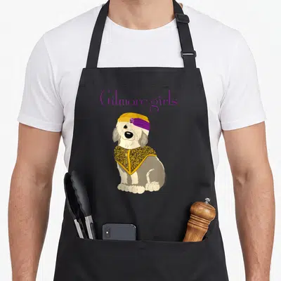 Paul gilmore girls apron - Cartoon dog in yellow turban and cape below purple Gilmore girls text on grey background — shown on a black cotton canvas apron against a white background