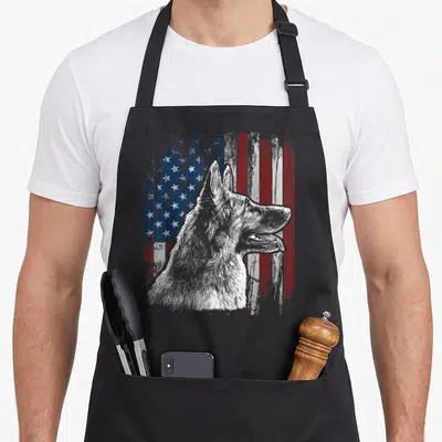 Patriotic german american flag apron - German Shepherd head profile superimposed over a distressed red white and blue — shown on a black cotton canvas apron against a white background