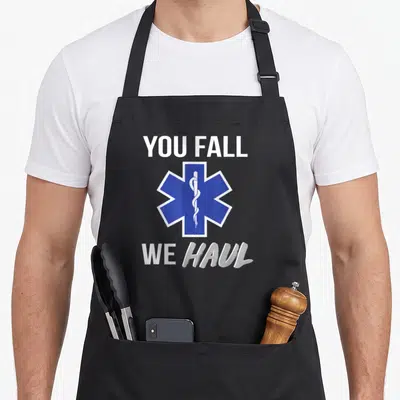 Haul fall apron - Blue Star of Life symbol between white You Fall We Haul text — shown on a black cotton canvas apron against a white background