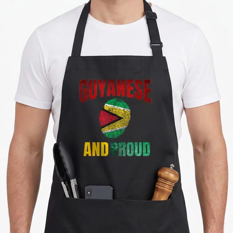 Fingerprint guyana apron - Distressed GUYANESE AND PROUD text surrounding a red green yellow white fingerprint — shown on a black cotton canvas apron against a white background