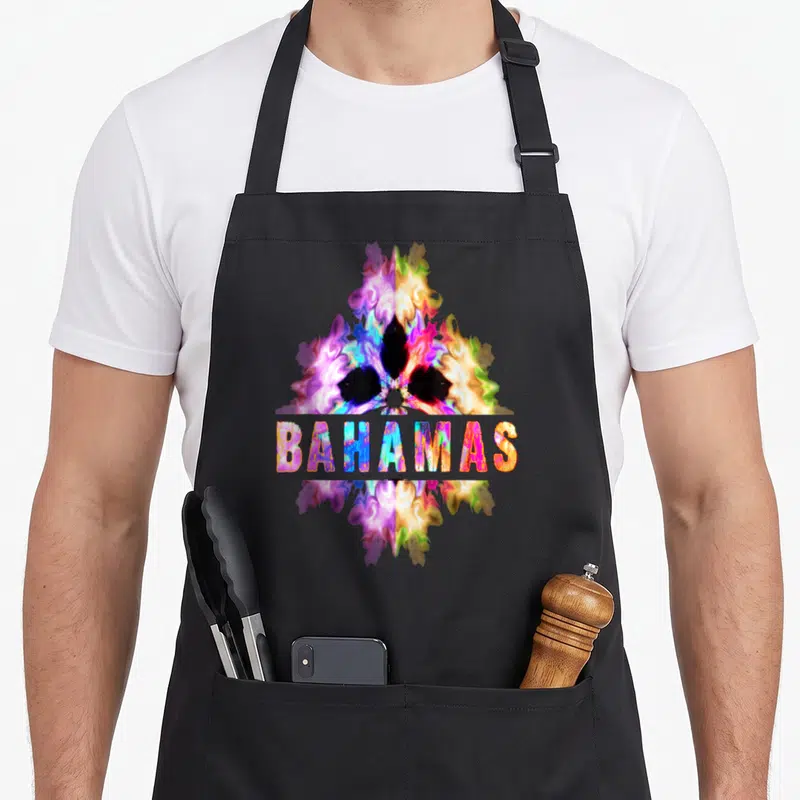 Cultural bahamian apron - Abstract tie-dye shape in purple pink yellow blue with BAHAMAS text overlay — shown on a black cotton canvas apron against a white background