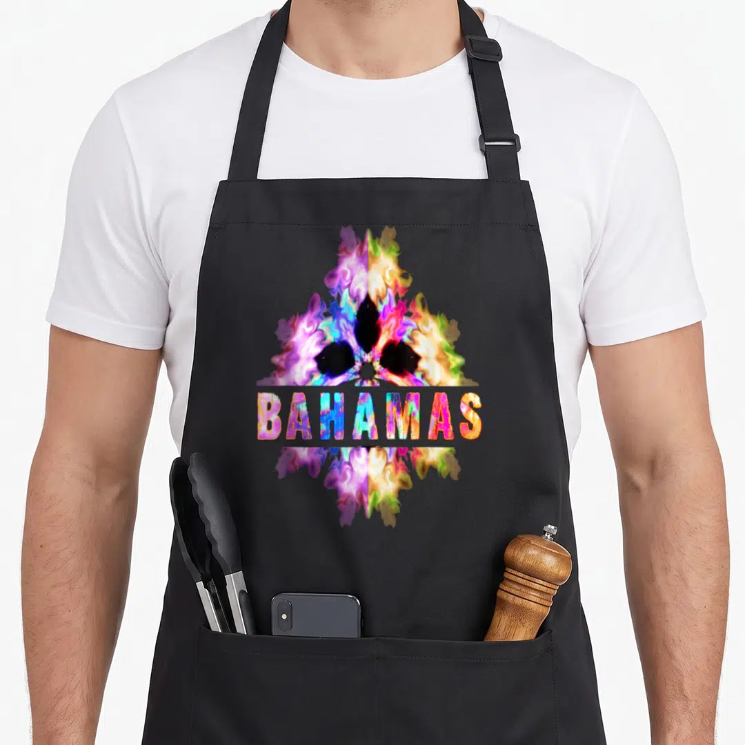 Cultural bahamian apron - Abstract tie-dye shape in purple pink yellow blue with BAHAMAS text overlay — shown on a black cotton canvas apron against a white background