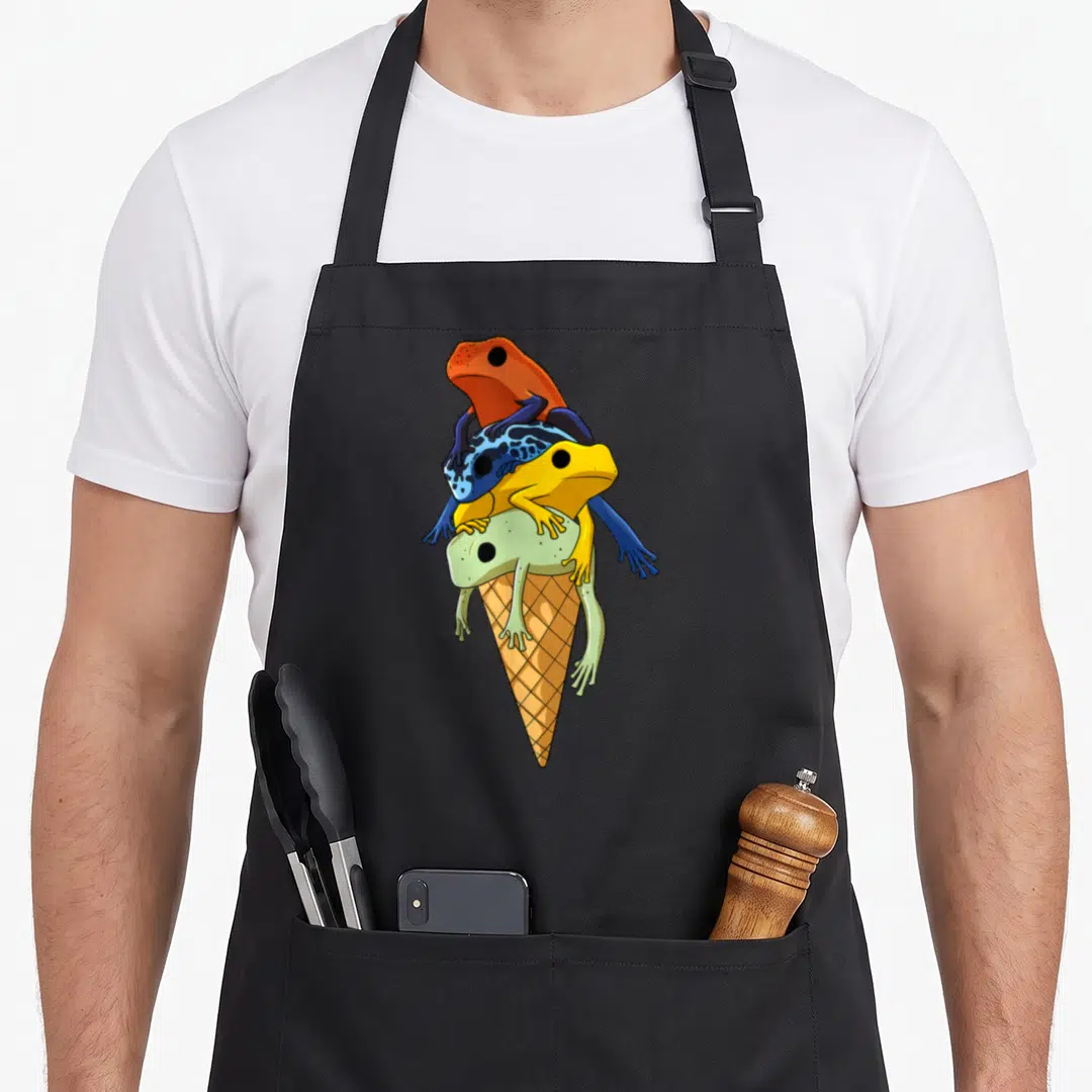 Tree ice cream apron - Four orange, blue, yellow, and green frogs stacked on a waffle cone — shown on a black cotton canvas apron against a white background