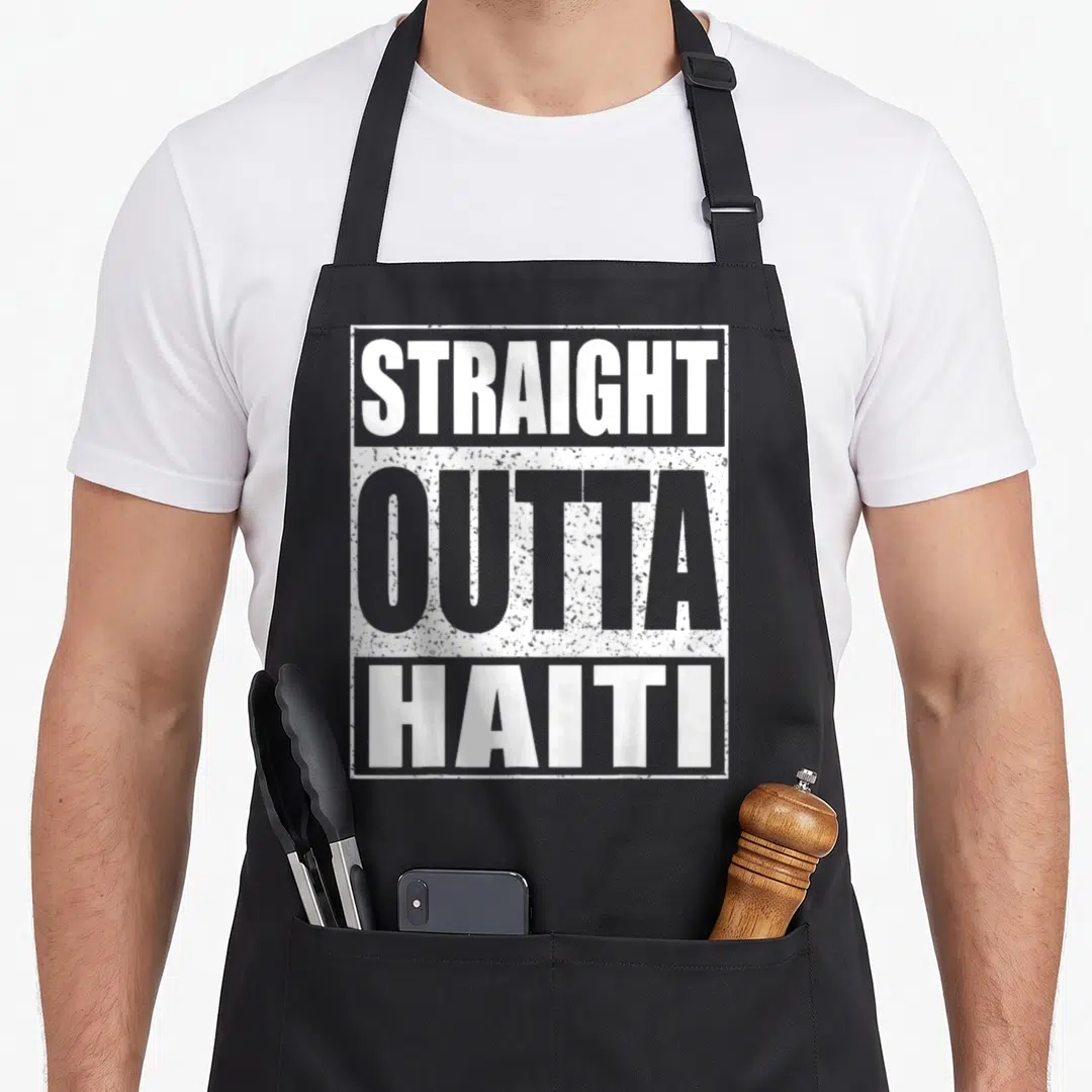 Straight national coffee day apron - Stacked white and grey distressed text reading STRAIGHT OUTTA HAITI inside — shown on a black cotton canvas apron against a white background