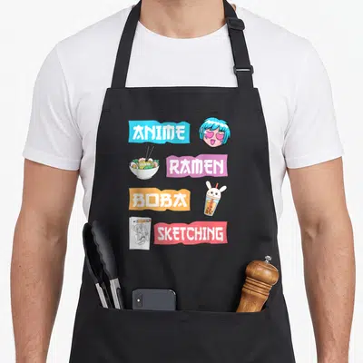 Boba anime apron - ANIME RAMEN BOBA SKETCHING banners with anime head, ramen, boba, and sketchbook illustrations — shown on a black cotton canvas apron against a white background